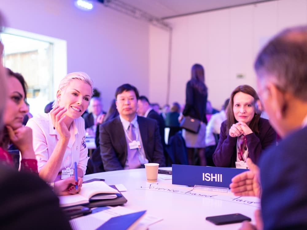 Attendees talking around a table at a professional association conference